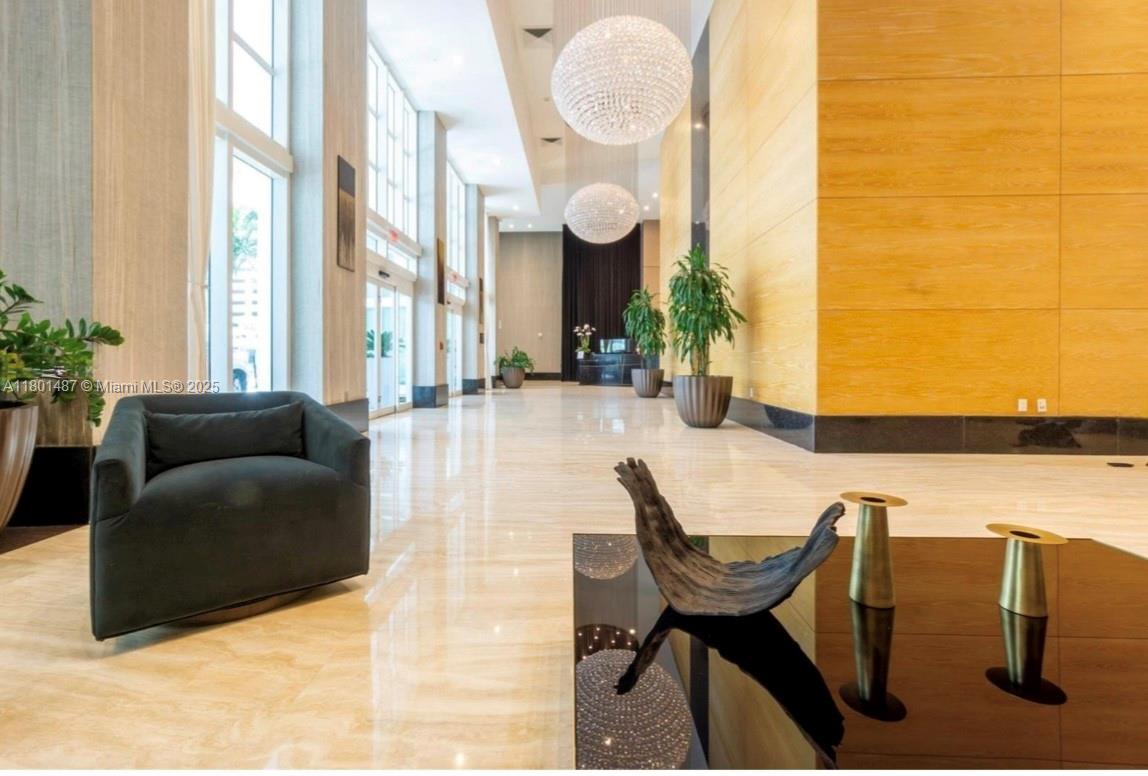 950 Brickell Bay Drive, Unit 401 Miami, FL 33131 - Photo 27 of 28 a living room with furniture a large window and a potted plant