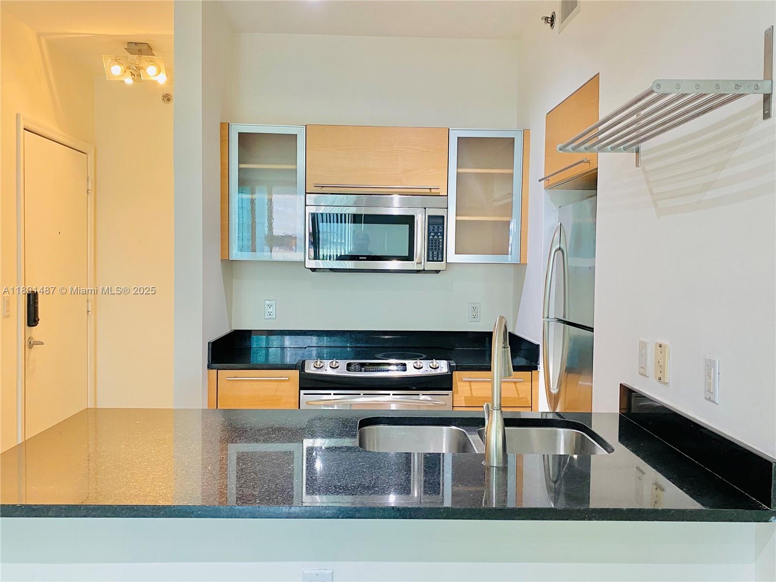 950 Brickell Bay Drive, Unit 401 Miami, FL 33131 - Photo 3 of 28 a kitchen with a sink a counter top space and cabinets