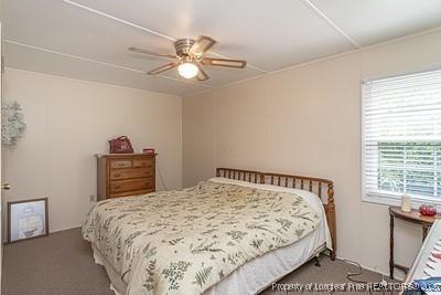 1012 Asbury Road Eastover, NC 28312 - Photo 17 of 38 a bedroom with a bed and a chandelier