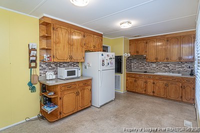 1012 Asbury Road Eastover, NC 28312 - Photo 6 of 38 a kitchen with stainless steel appliances granite countertop a stove refrigerator and cabinets