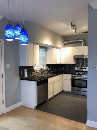 a kitchen with granite countertop stainless steel appliances and wooden cabinets