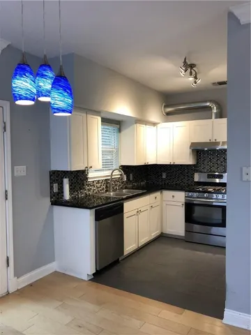 a kitchen with granite countertop stainless steel appliances and wooden cabinets