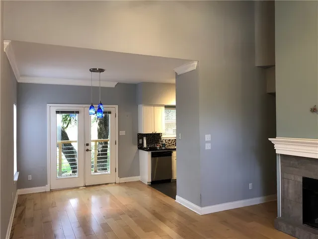 an empty room with windows and fireplace