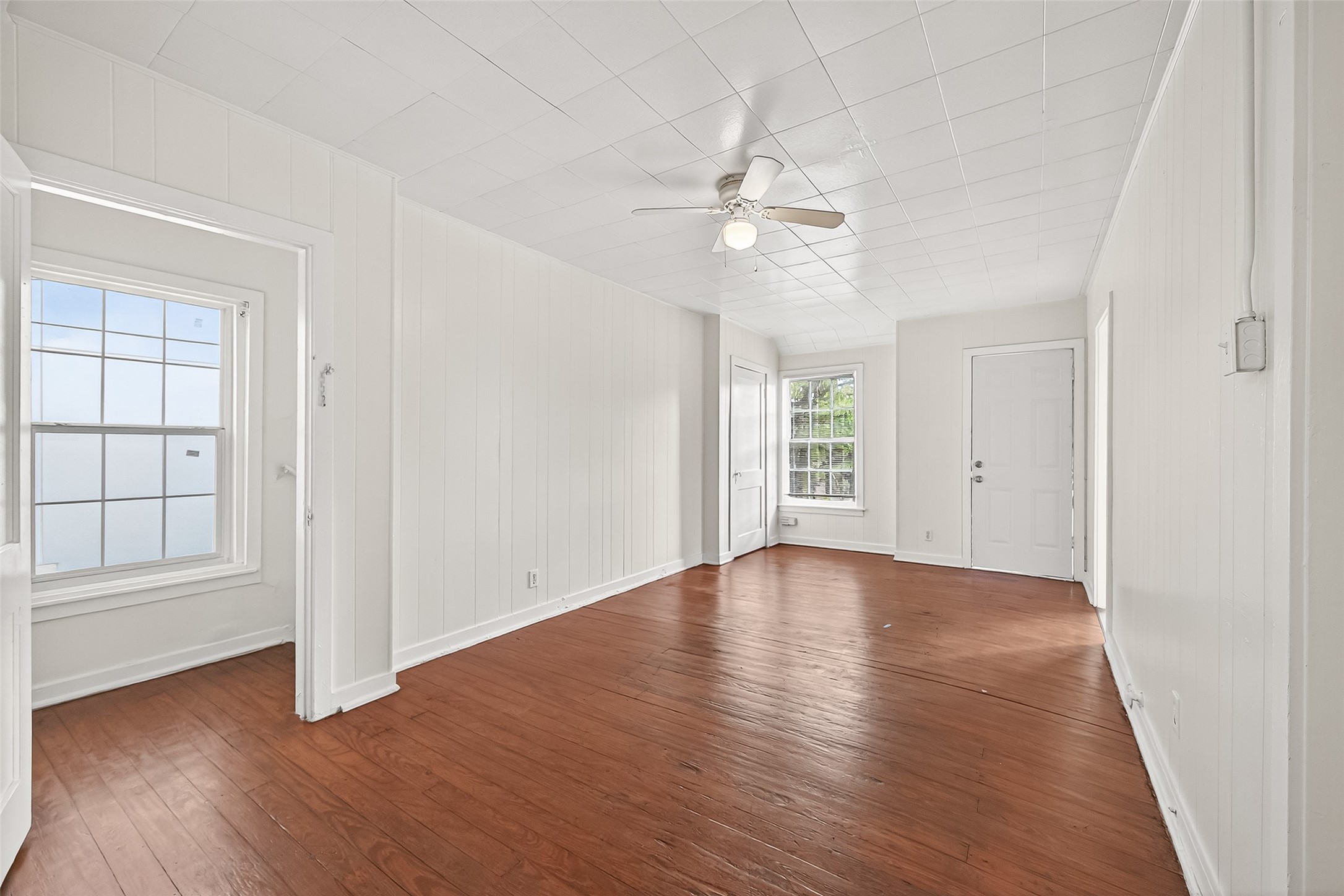 4212 Woodhead Street, Unit 2 Houston, TX 77098 - Photo 6 of 26 an empty room with wooden floor chandelier fan and windows
