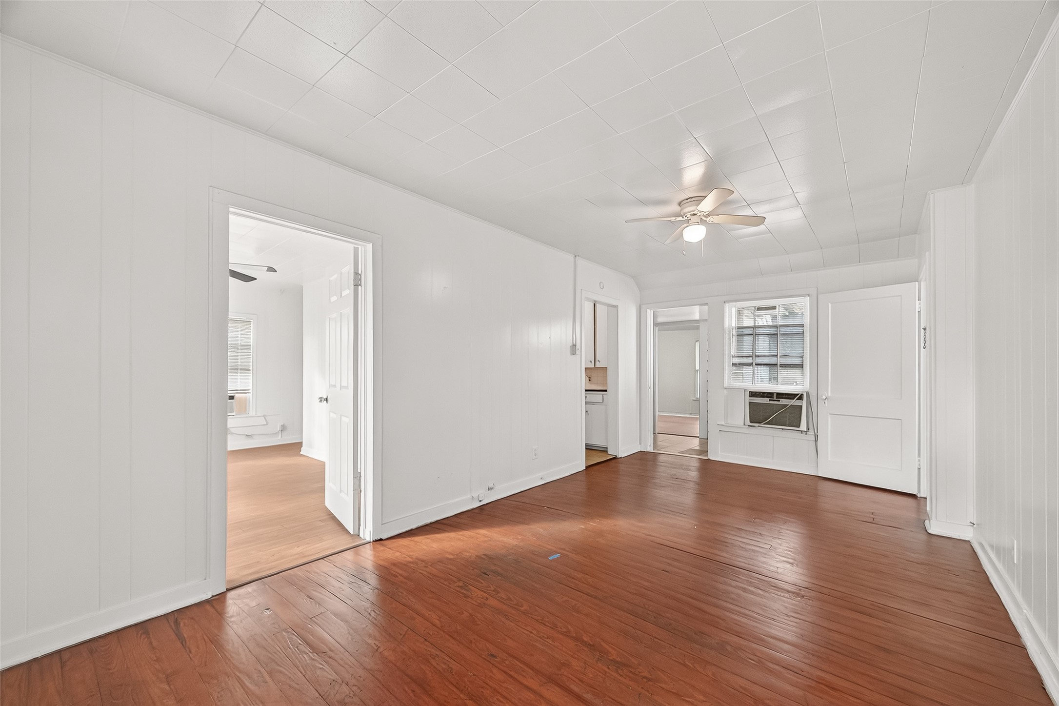 4212 Woodhead Street, Unit 2 Houston, TX 77098 - Photo 8 of 26 an empty room with wooden floor chandelier fan and windows
