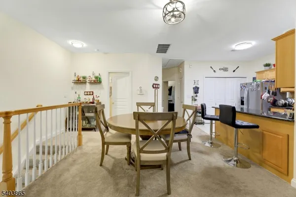a view of a dining room and livingroom with furniture a rug a chandelier and wooden floor