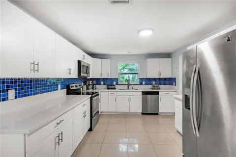 a kitchen with a sink a refrigerator and cabinets