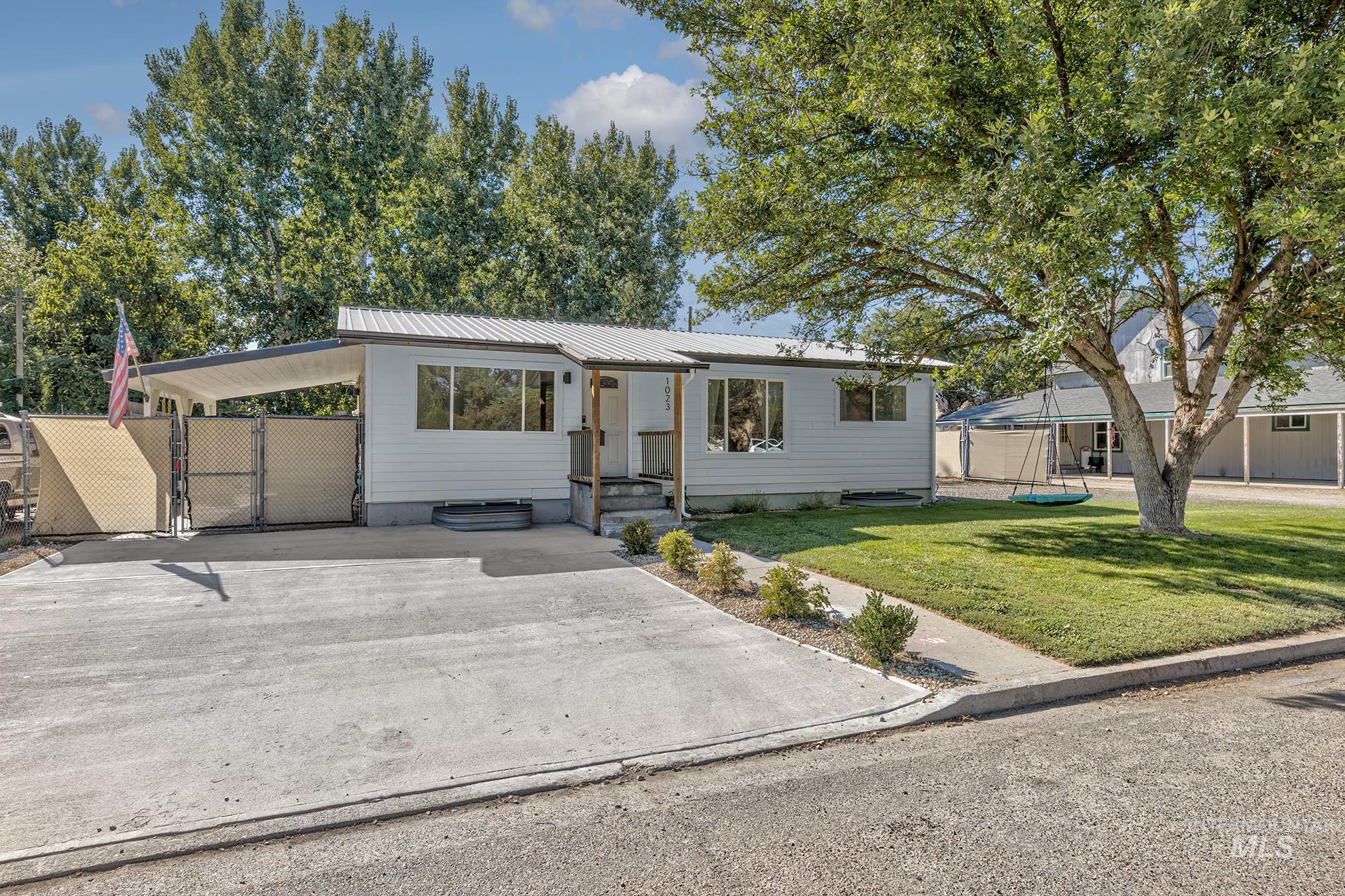 1023 West 6th Street Weiser, ID 83672 - Photo 1 of 1 Bungalow with a metal roof, concrete driveway, a carport, and a gate