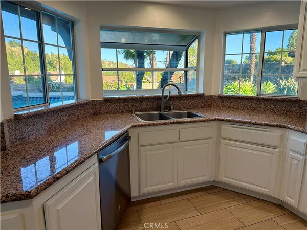 a kitchen with granite countertop stainless steel appliances a refrigerator and cabinets