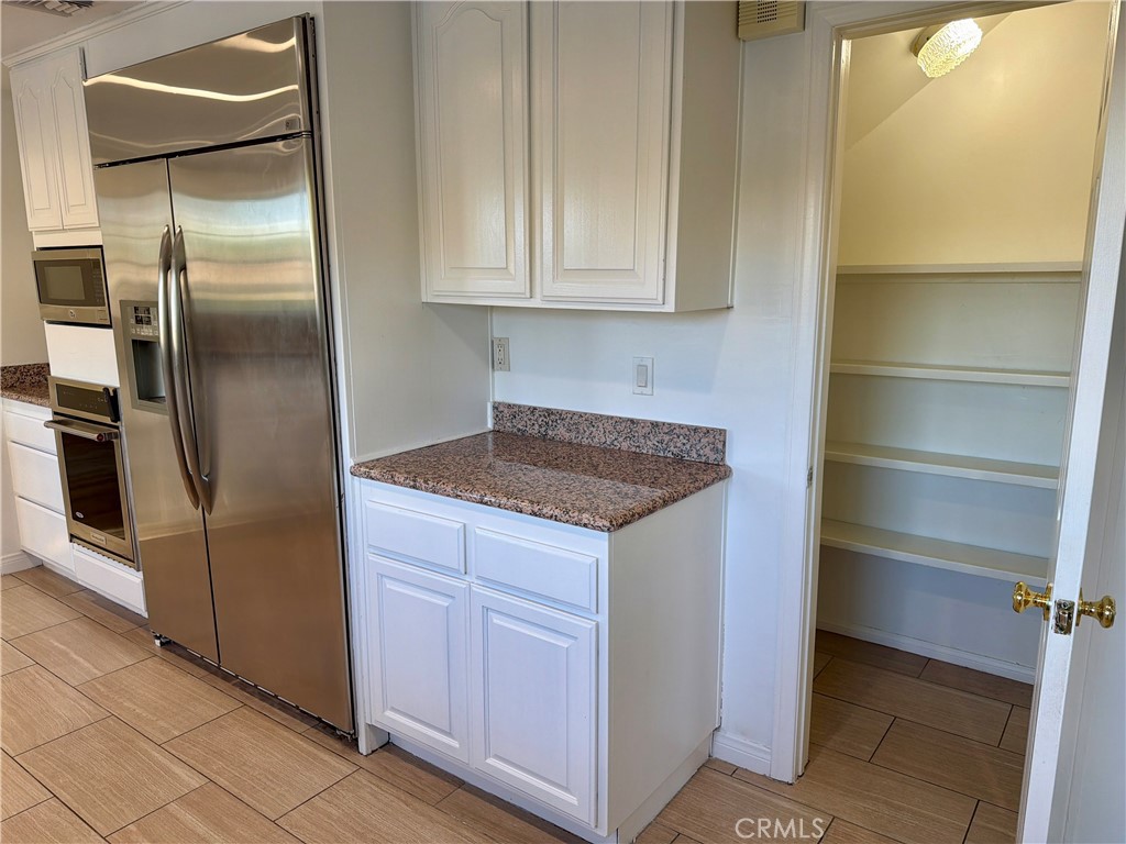 11932 Sonoma Way Porter Ranch, CA 91326 - Photo 18 of 63 a kitchen with granite countertop stainless steel appliances a refrigerator and cabinets