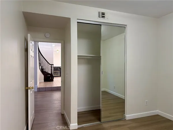 a view of a hallway with wooden floor and staircase