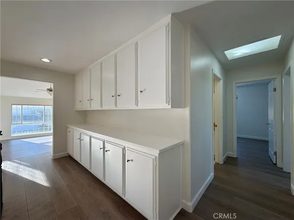 a view of a hallway with wooden floor and closet