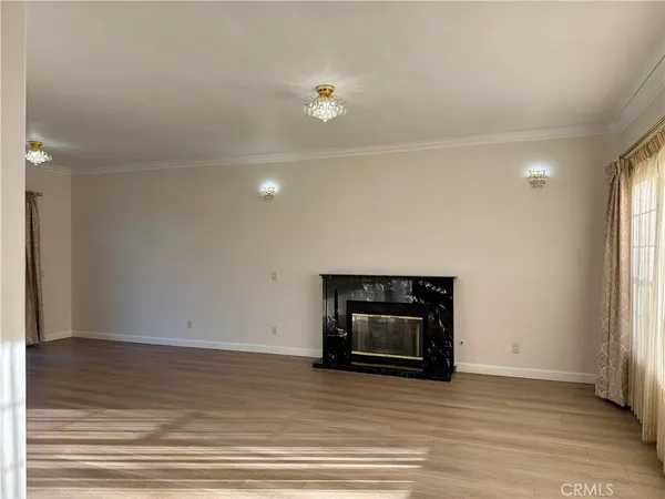 a view of empty room with wooden floor and fireplace