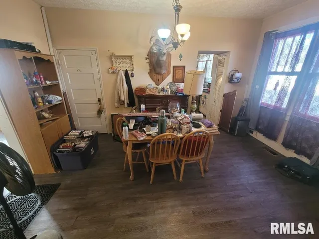 a dining room with furniture a chandelier and wooden floor