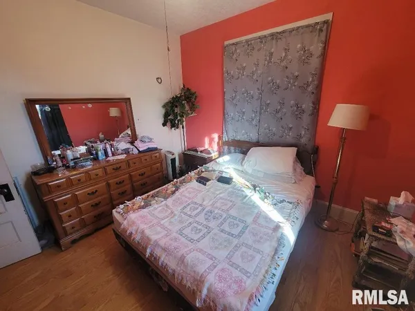 a bedroom with bed and a lamp on table