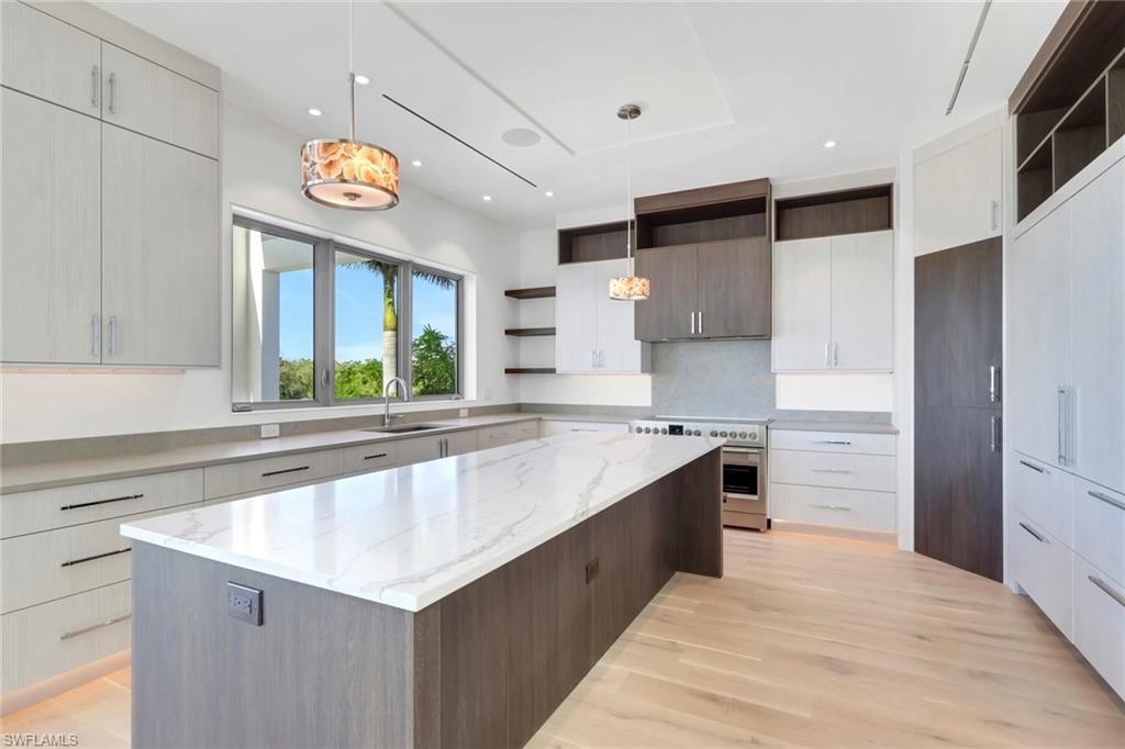 1798 Holiday Lane Naples, FL 34104 - Photo 5 of 31 a large kitchen with a large counter top a stove and a window