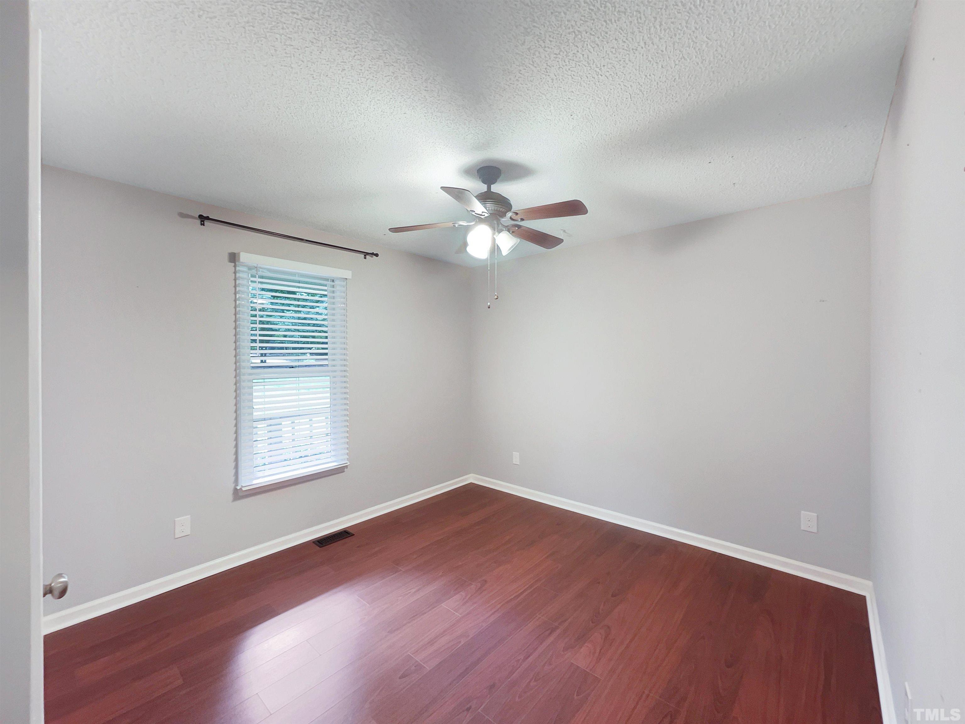 2025 Canterbury Road Clayton, NC 27520 - Photo 11 of 18 an empty room with a window and a ceiling fan