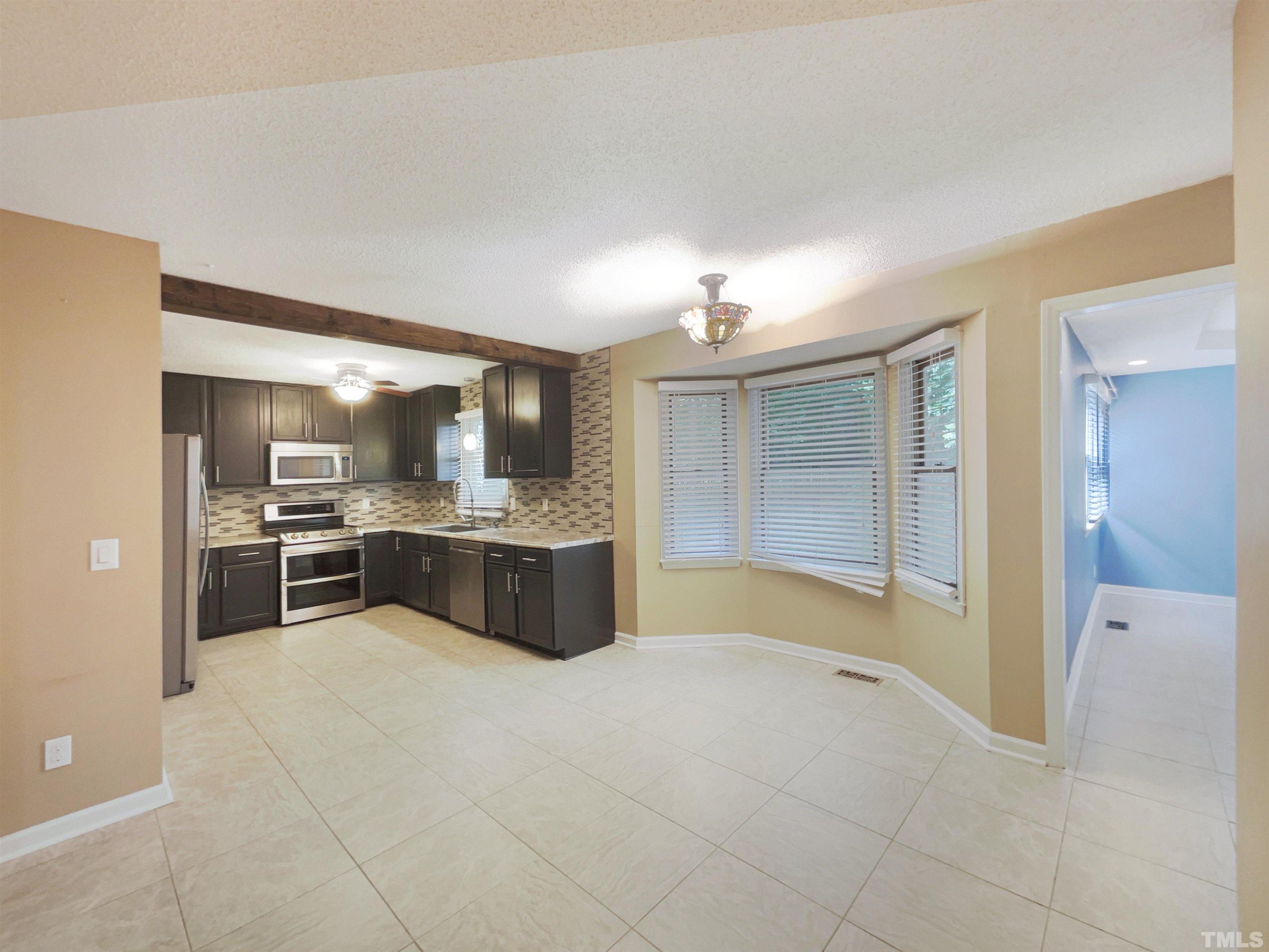 2025 Canterbury Road Clayton, NC 27520 - Photo 14 of 18 a large kitchen with a sink and cabinets
