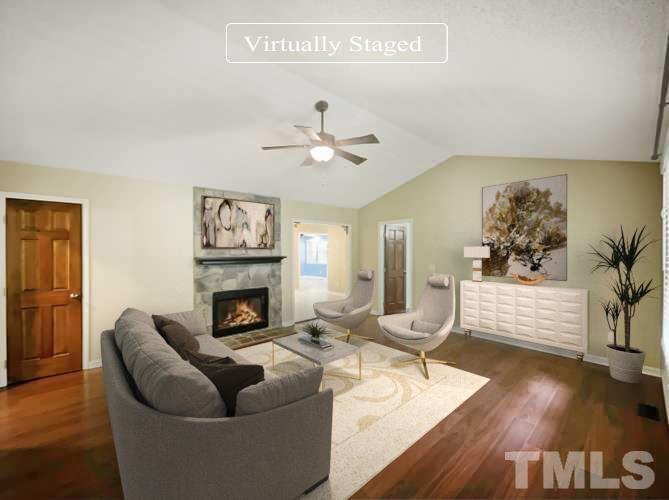 2025 Canterbury Road Clayton, NC 27520 - Photo 2 of 18 a living room with furniture fireplace and wooden floor