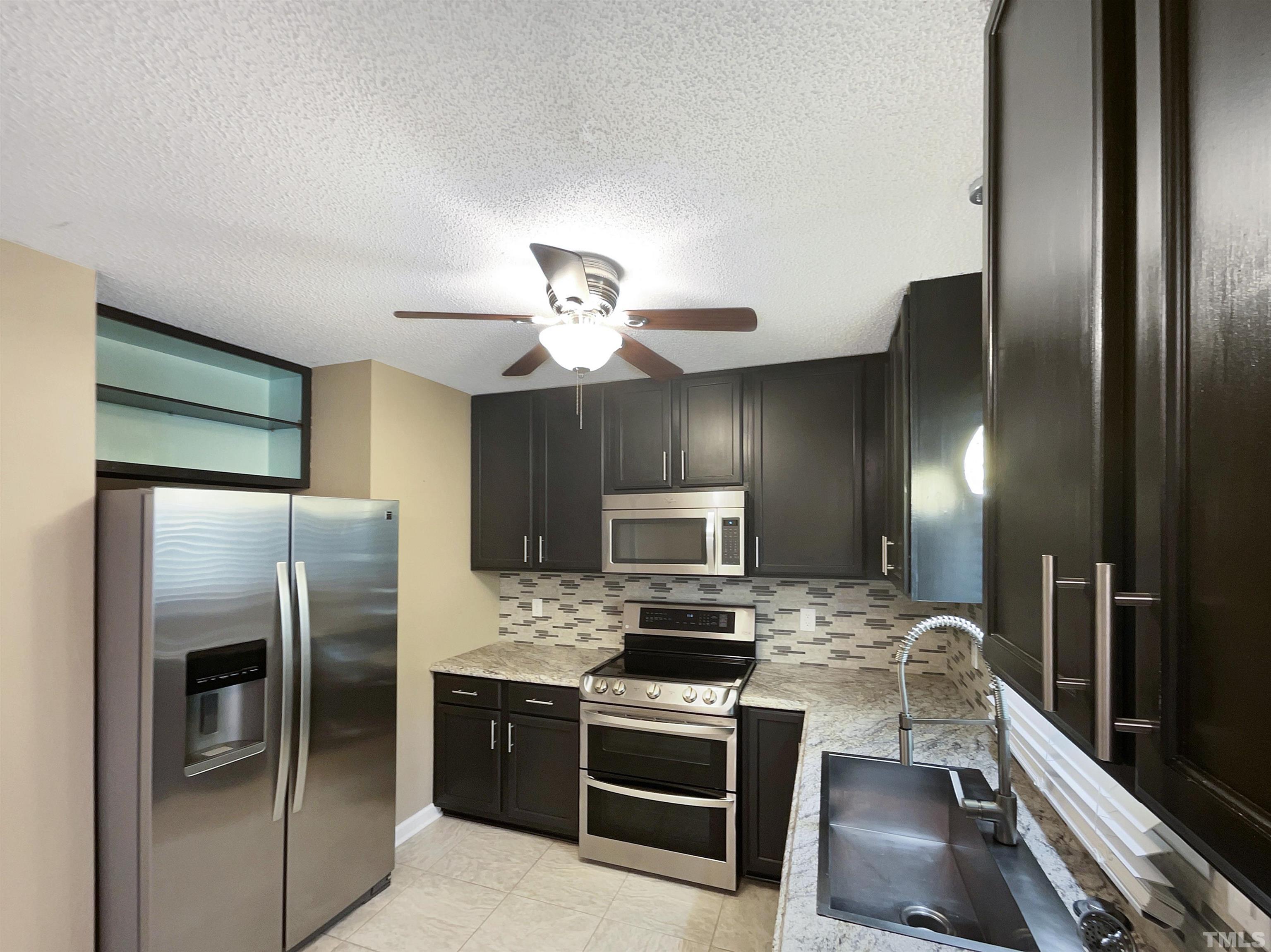 2025 Canterbury Road Clayton, NC 27520 - Photo 4 of 18 a kitchen with a refrigerator sink and microwave