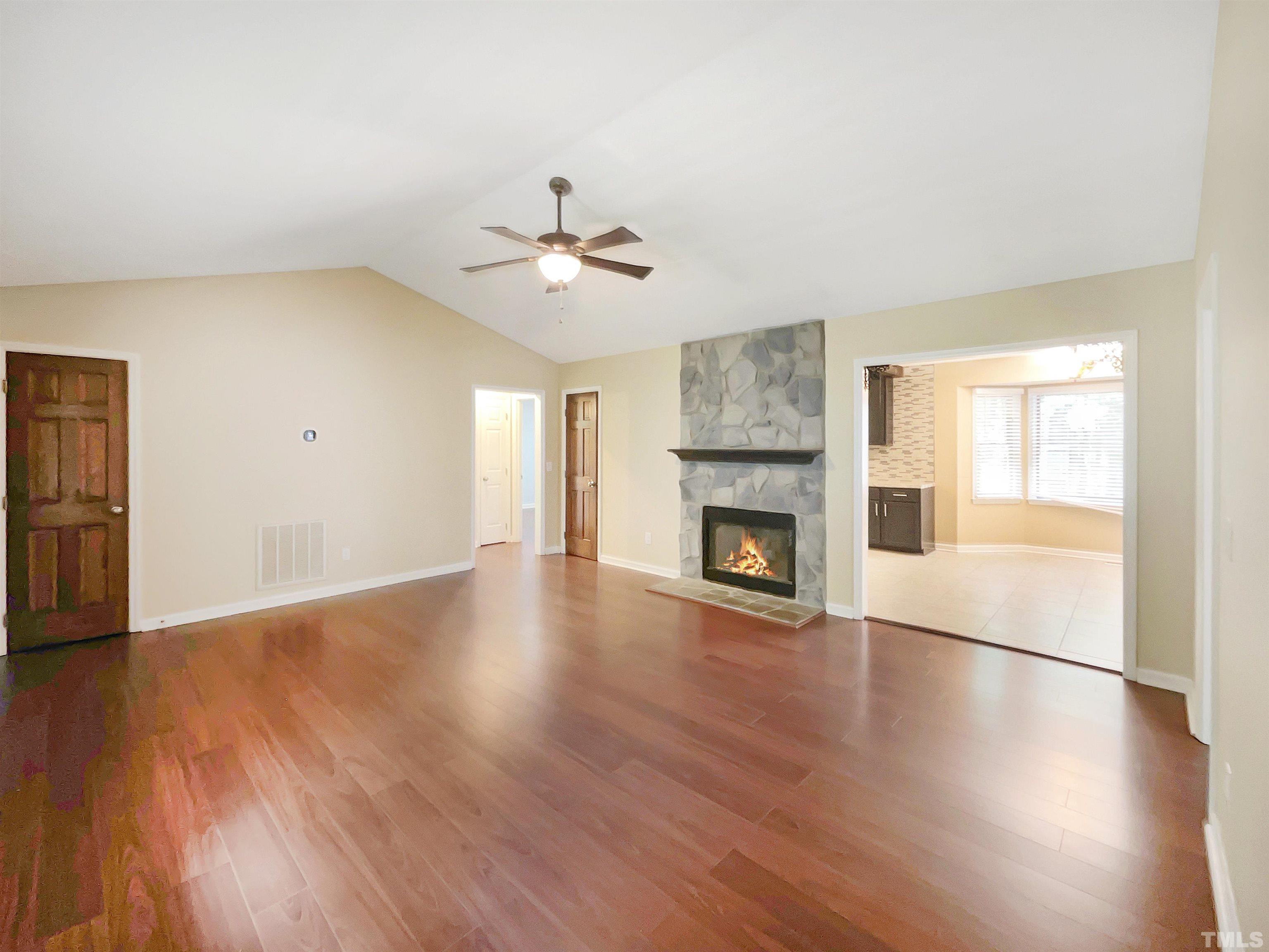 2025 Canterbury Road Clayton, NC 27520 - Photo 5 of 18 a view of an empty room with wooden floor and a fireplace
