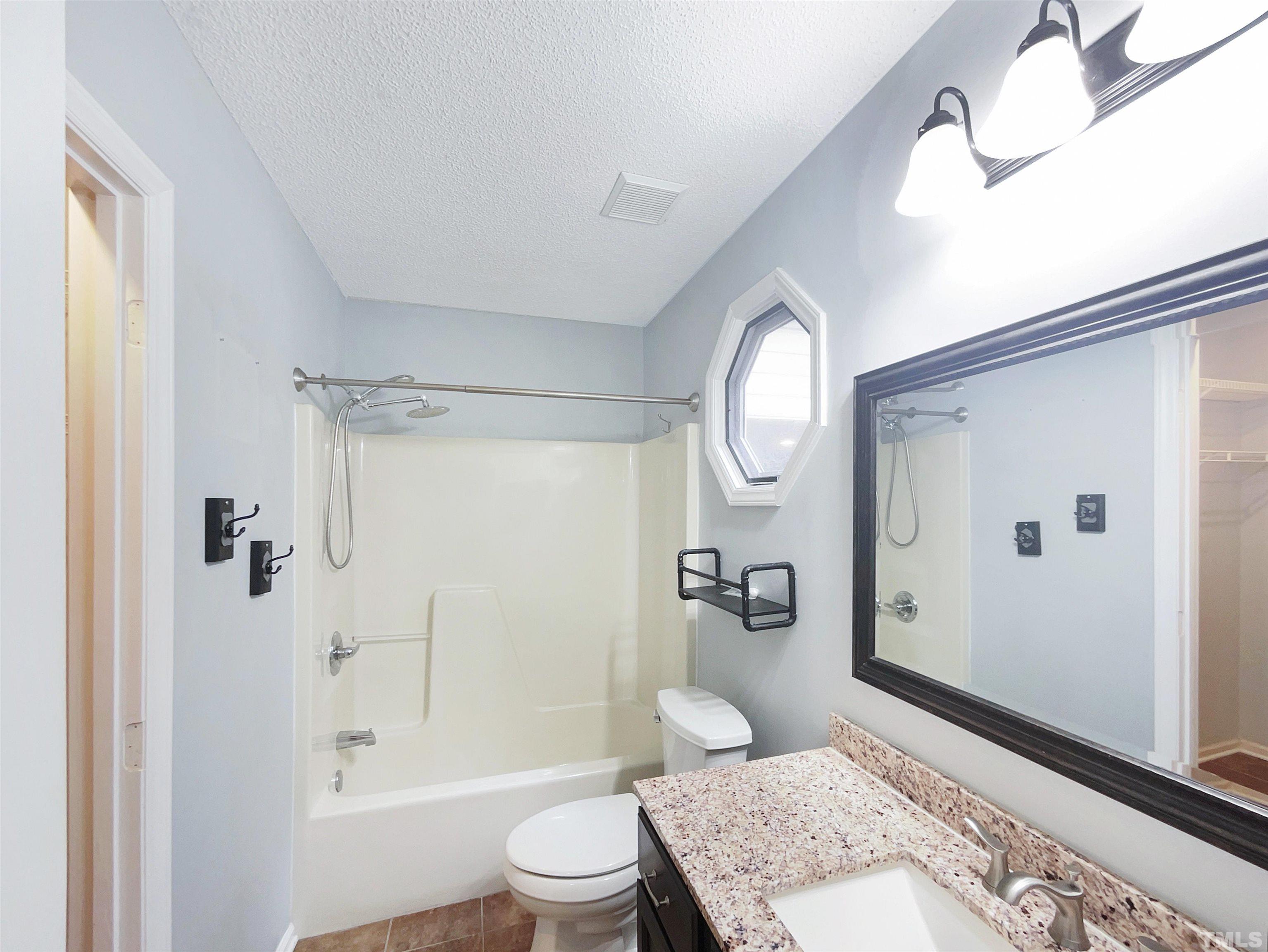 2025 Canterbury Road Clayton, NC 27520 - Photo 6 of 18 a spacious bathroom with a granite countertop sink toilet a mirror and shower