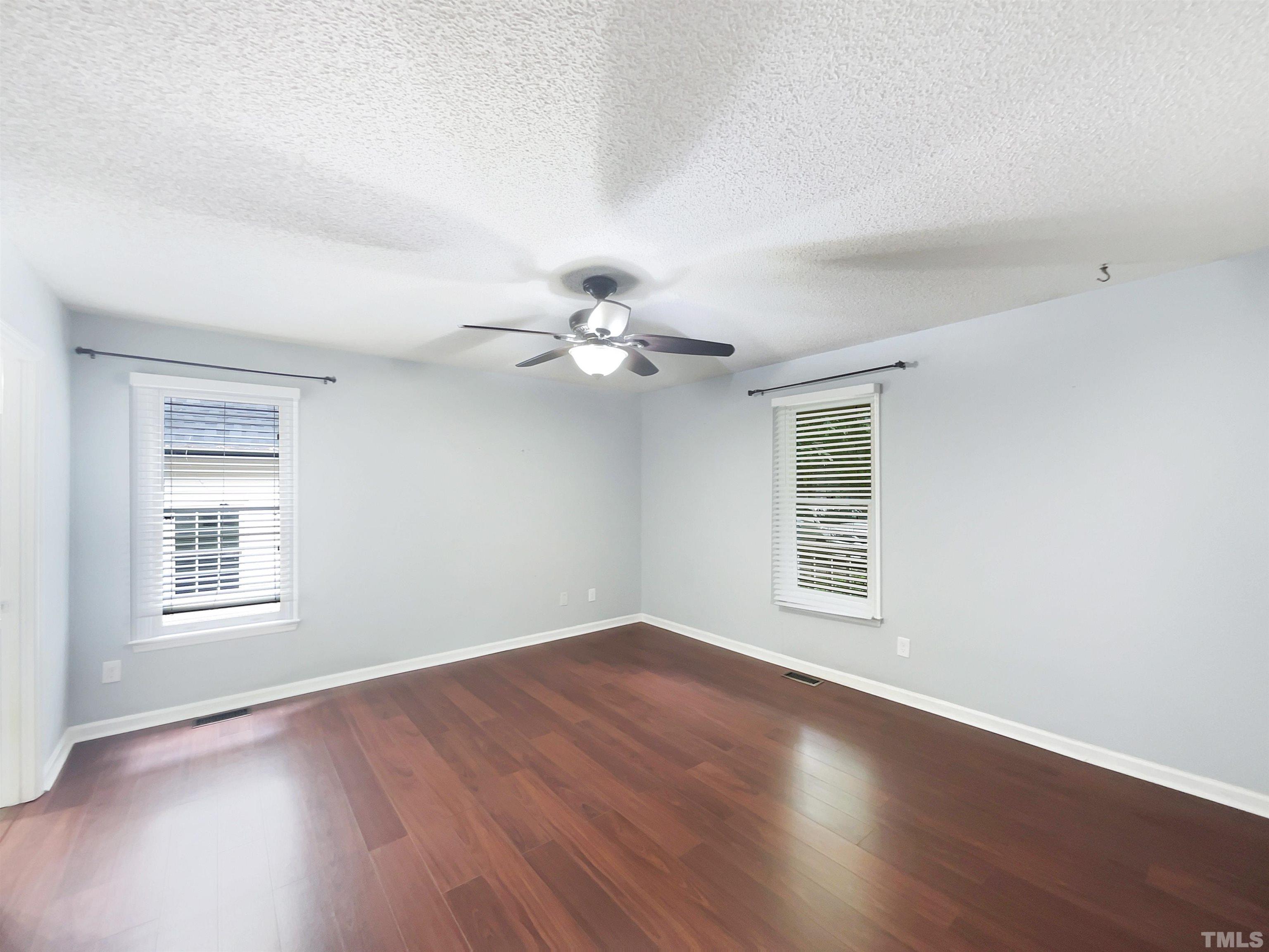 2025 Canterbury Road Clayton, NC 27520 - Photo 8 of 18 a view of an empty room with wooden floor and a window