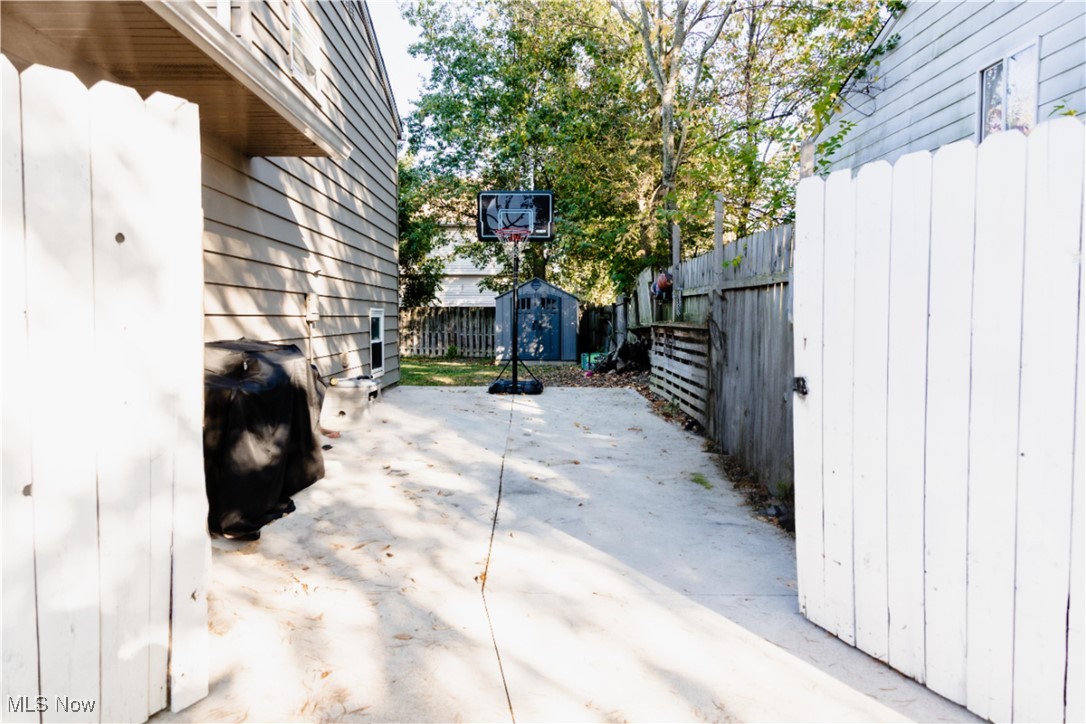 5861 Lee Avenue North Ridgeville, OH 44039 - Photo 19 of 20 Fenced backyard with a storage unit, a patio, and a grill