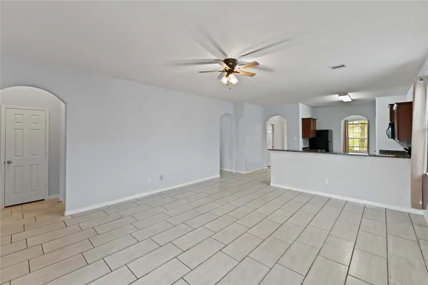 an empty room with fan and windows