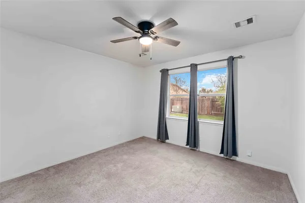 a view of an empty room with a ceiling fan