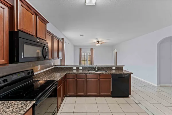 a kitchen with stainless steel appliances granite countertop a stove a sink and a microwave