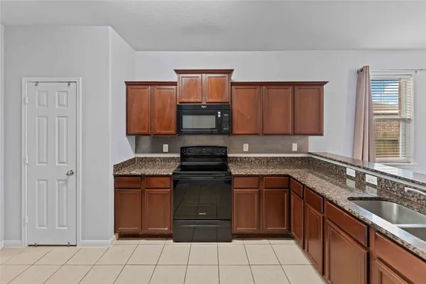 a kitchen with a stove top oven sink and cabinets