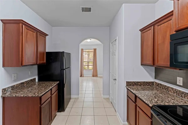 a kitchen with a refrigerator and a stove top oven