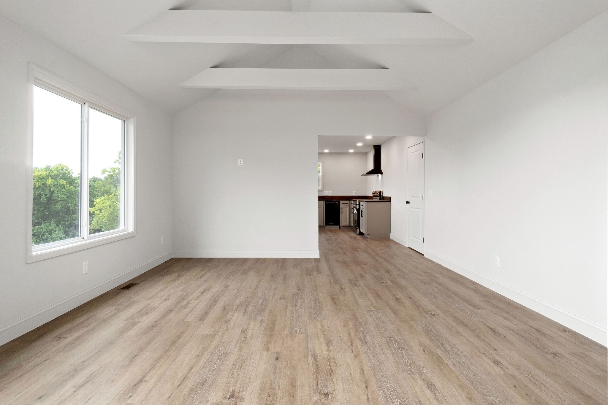 1124 Dale Ridge Road Dowelltown, TN 37059 - Photo 46 of 69 a view of a kitchen and an empty room with wooden floor and a window