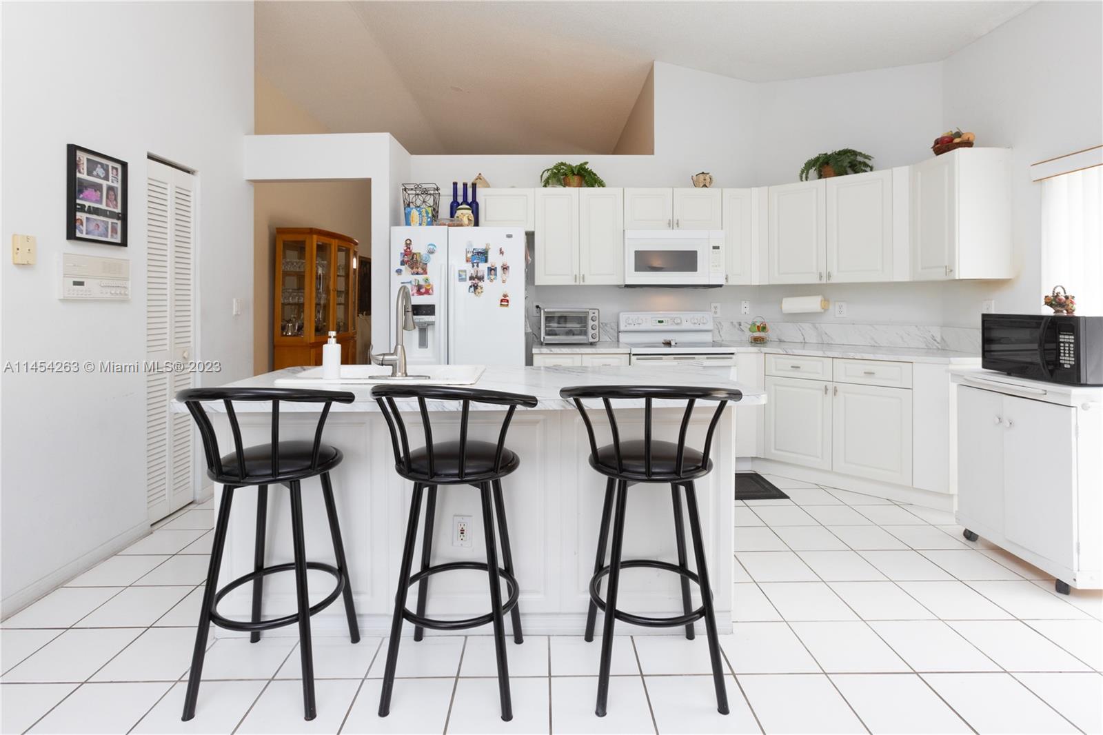 10067 Southwest 156th Avenue Miami, FL 33196 - Photo 5 of 21 a kitchen with stainless steel appliances a white refrigerator a stove a sink and white cabinets