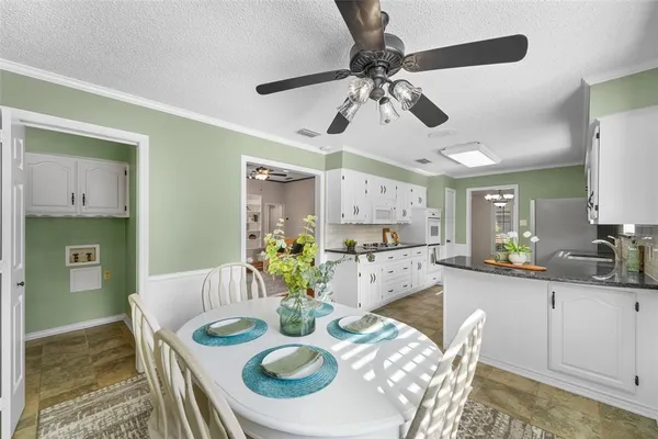 a large kitchen with stainless steel appliances kitchen island granite countertop lots of white cabinets and granite countertops