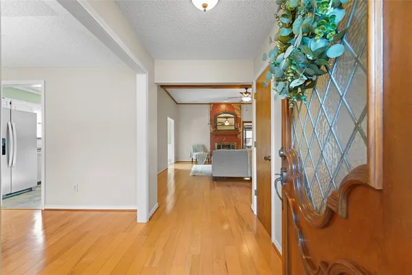a view of a hallway with wooden floor and a potted plant