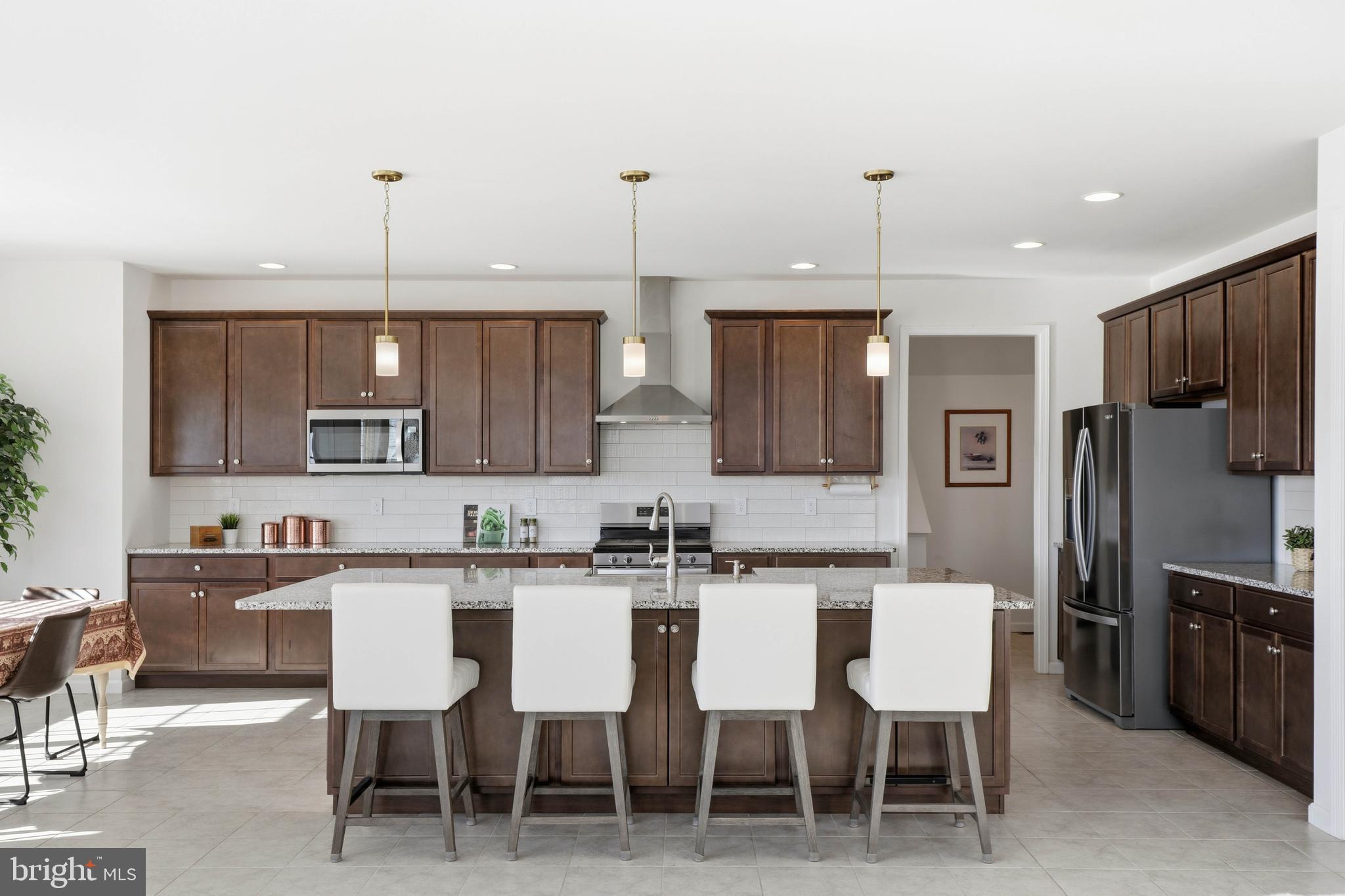 454 East Delp Road Lancaster, PA 17601 - Photo 18 of 78 a kitchen with stainless steel appliances kitchen island granite countertop a table chairs microwave and sink