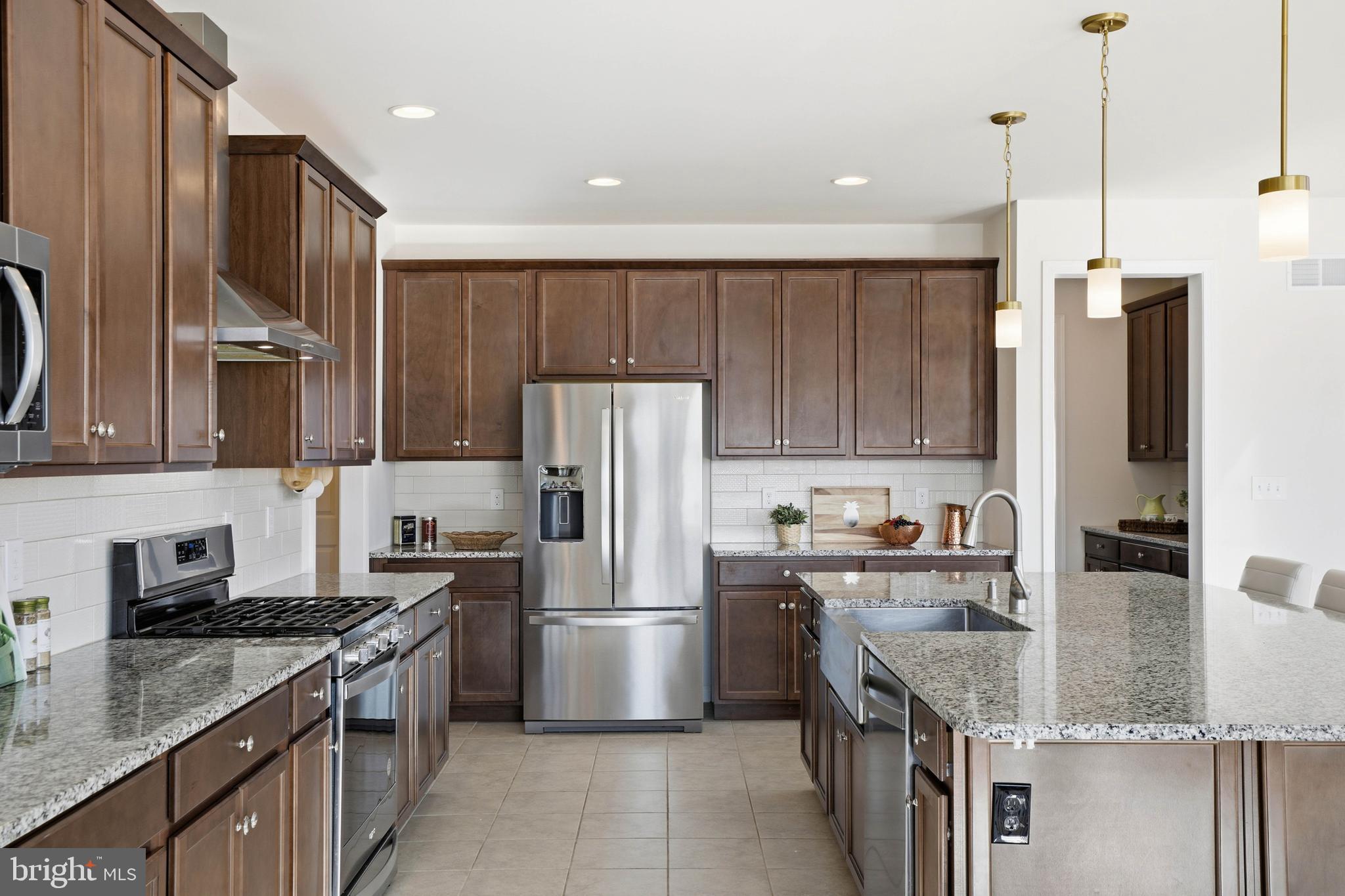 454 East Delp Road Lancaster, PA 17601 - Photo 20 of 78 a kitchen with kitchen island granite countertop a sink refrigerator and microwave