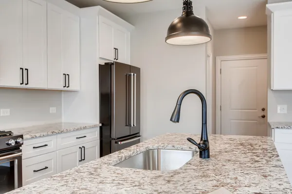 a kitchen with stainless steel appliances granite countertop a sink a stove and refrigerator