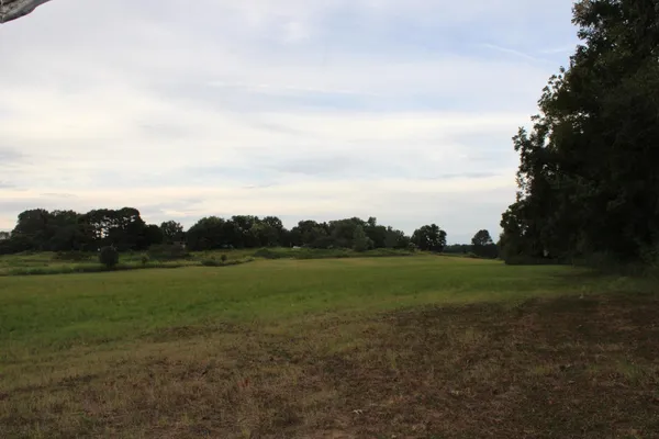 a view of field and trees in the background