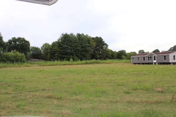 a white house that has a big yard with wooden fence