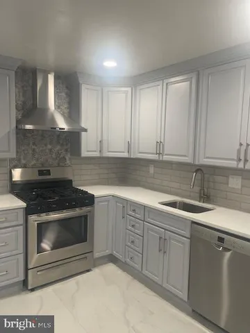 a kitchen with white cabinets and white appliances