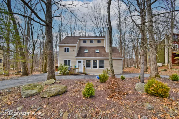 a front view of a house with a yard and tree s