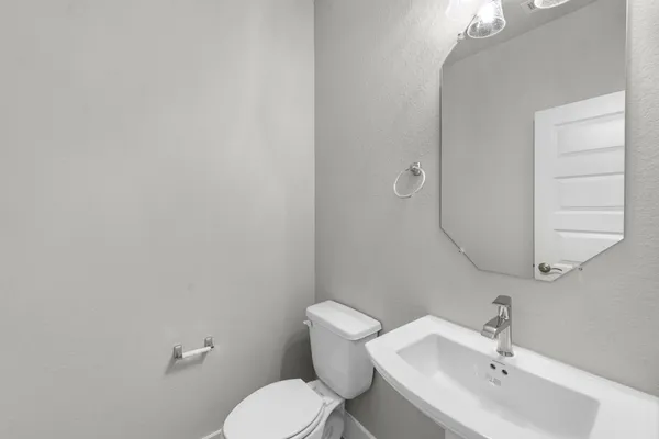 a bathroom with a toilet a sink and mirror