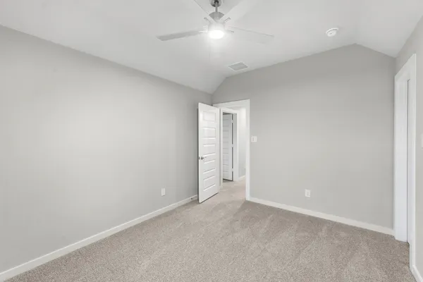 an empty room with a ceiling fan and bathroom