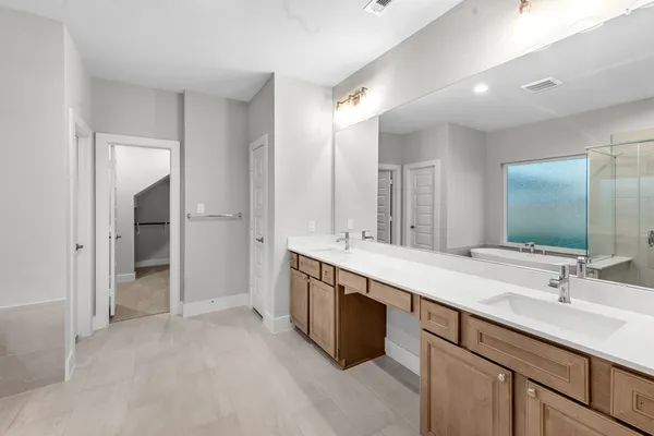 a bathroom with double sink and a mirror