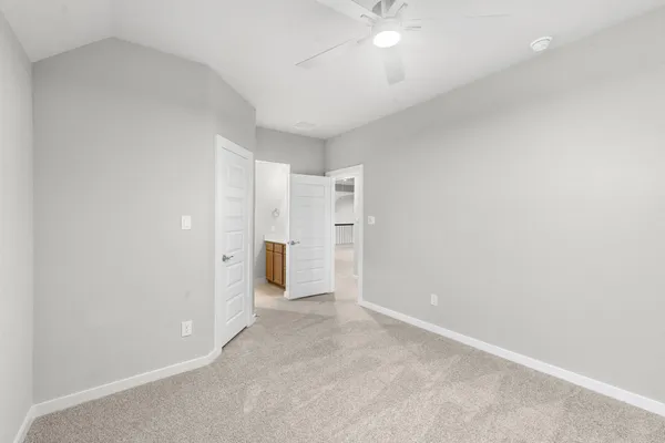 an empty room with an entryway and fan