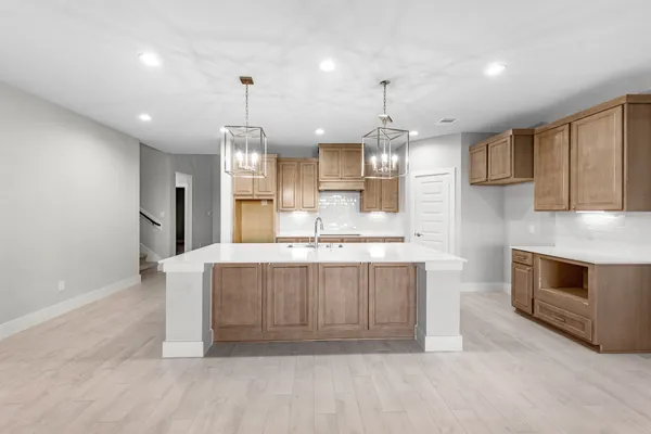 a large kitchen with stainless steel appliances granite countertop a stove a sink and a refrigerator