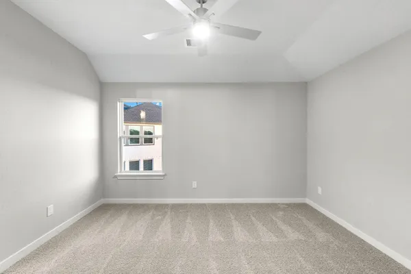 an empty room with a window and a fan